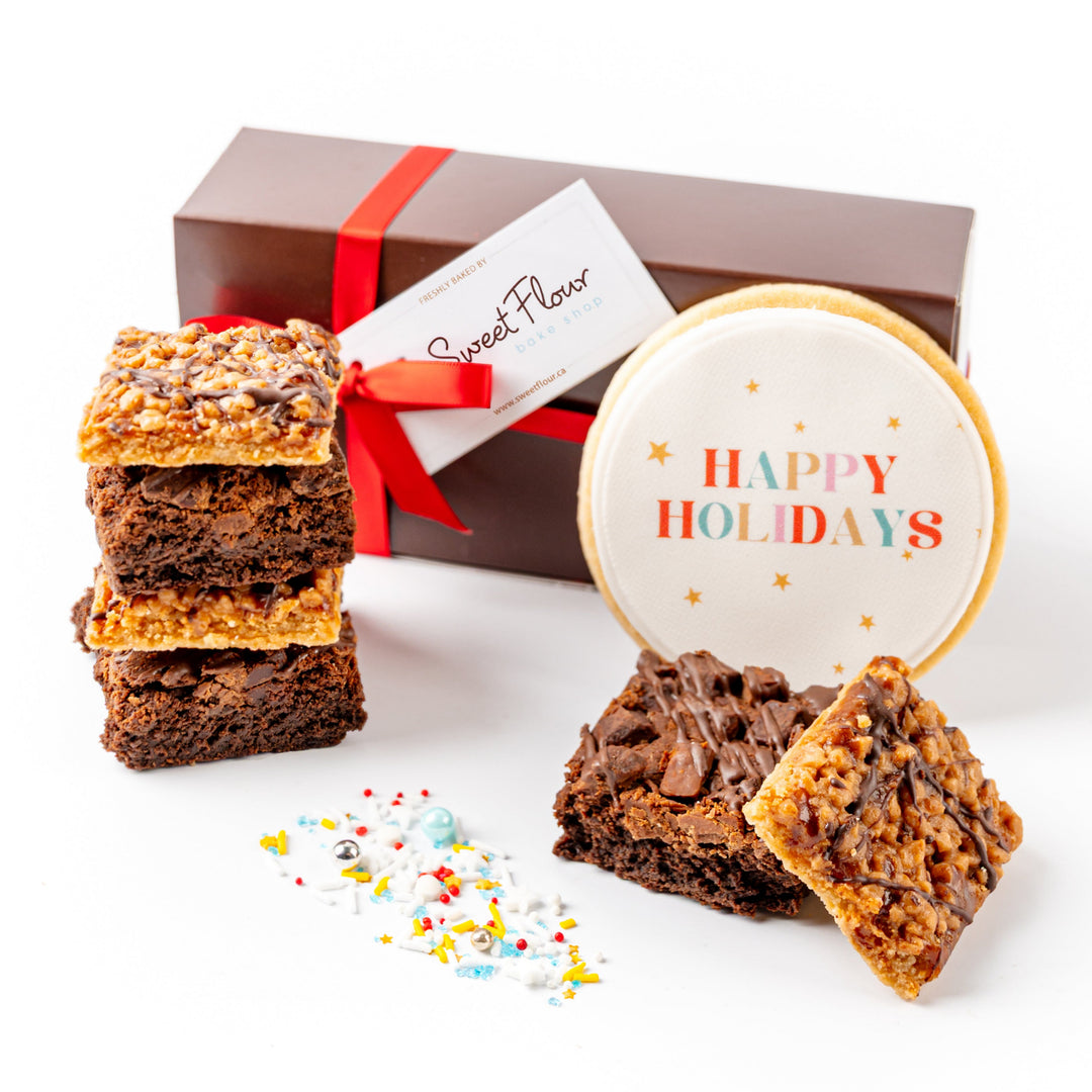 Brownies with a 'Happy Holidays' cookie and gift box on a white background
