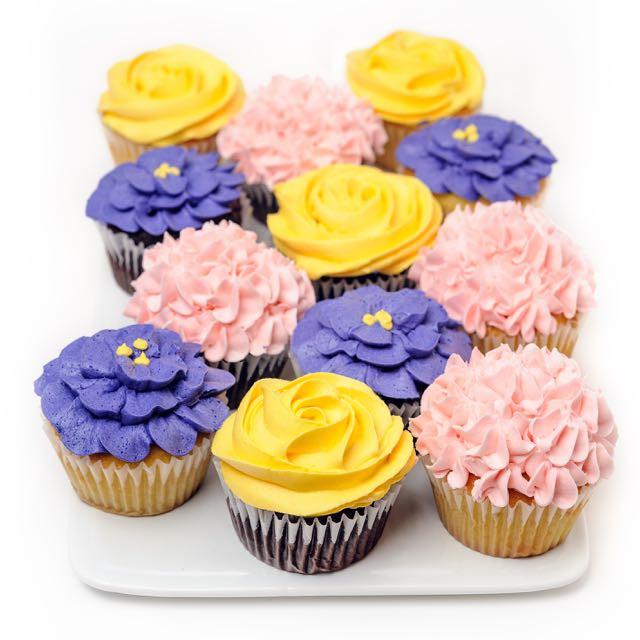 one dozen  Mother's Day  cupcakes with purple, pink and yellow flowers frosting