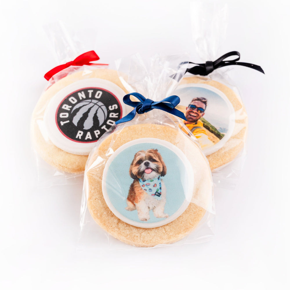 Three sugar cookies with different custom designs on a white background