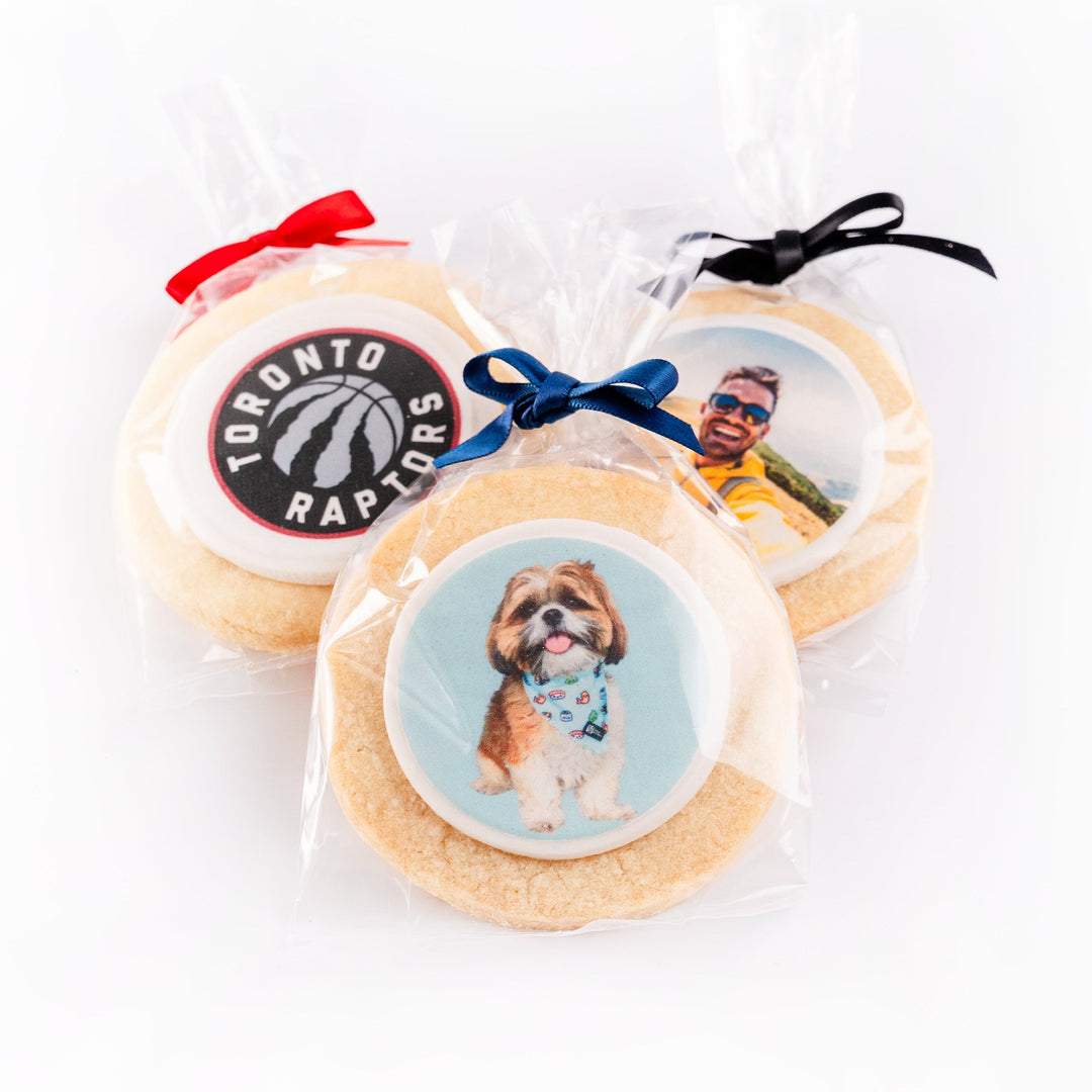 Three sugar cookies with different custom designs on a white background