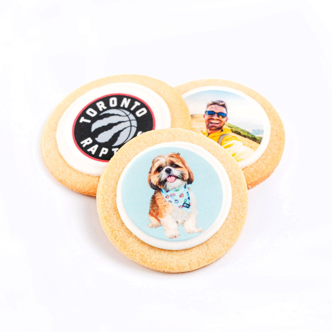 Three sugar cookies with different custom designs on a white background