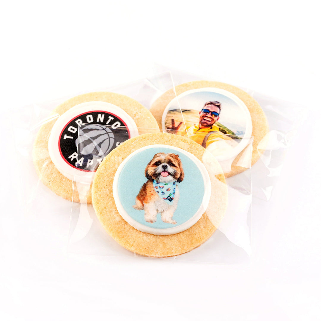 Three sugar cookies with different custom designs on a white background