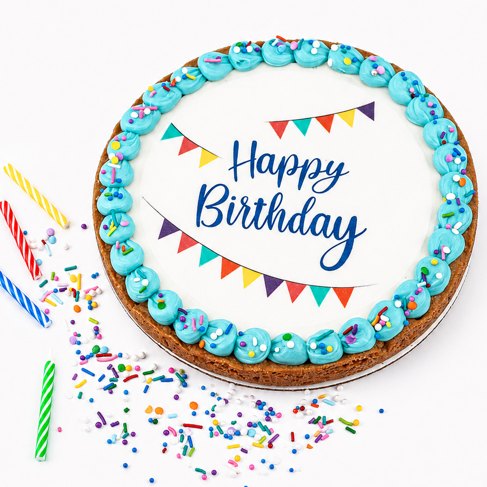 A round birthday cake with white icing, blue piped frosting around the edge, colorful bunting flags, and 'Happy Birthday' written in blue script. The cake is decorated with sprinkles and surrounded by colorful birthday candles on a white background.