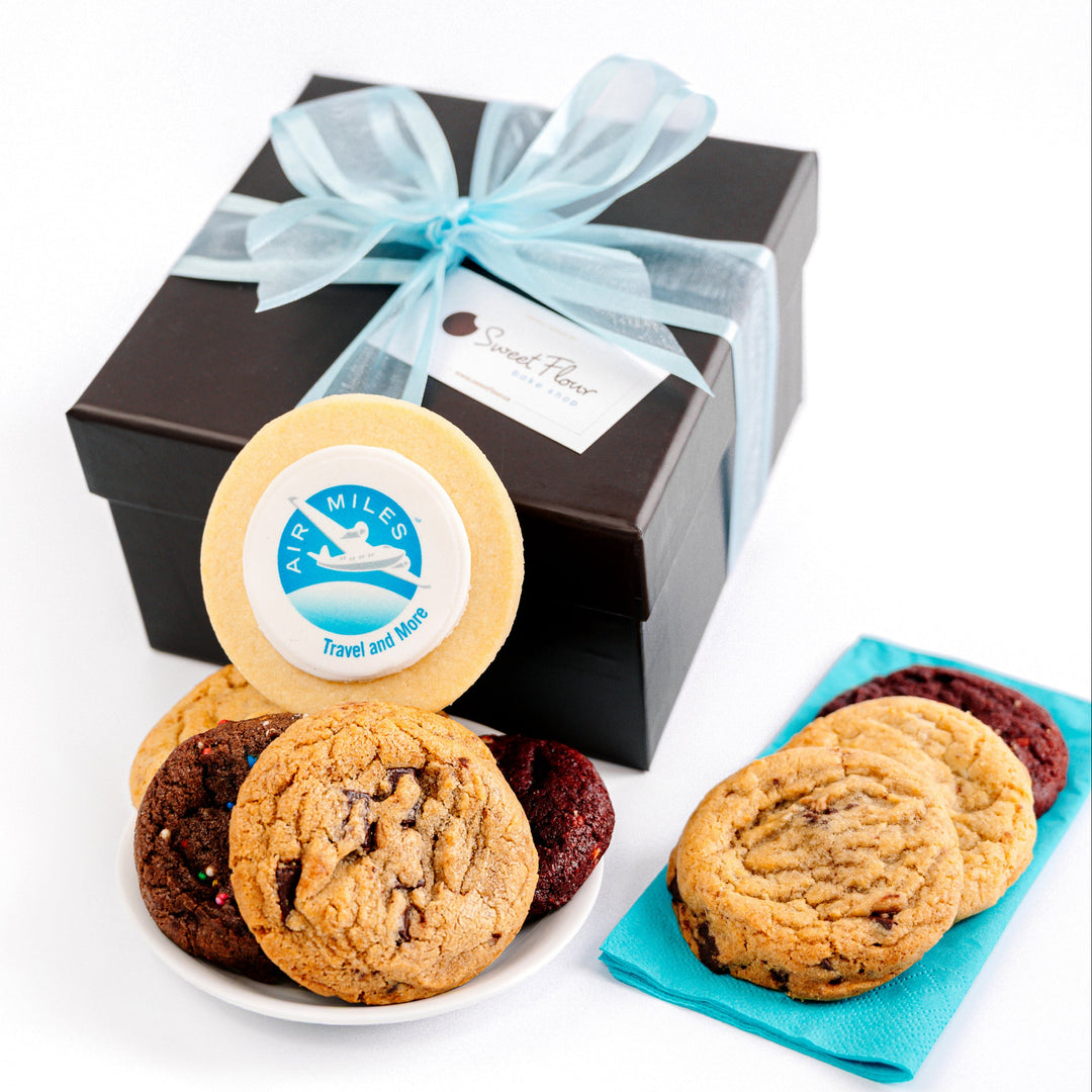 Box of assorted cookies with a blue ribbon on a white background and a custom Air Miles logo cookie
