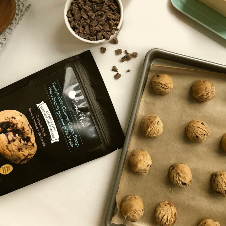 holiday cookie dough balls on a baking tray beside an empty bag of cookie dough mix