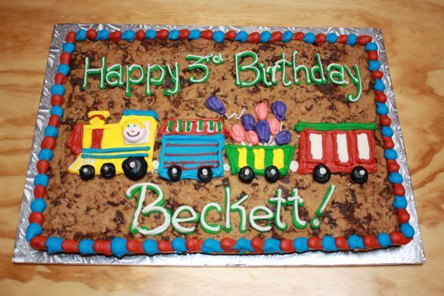 12 by 16 inch giant Happy Birthday Beckett Cookie Cake with train and balloons in icing